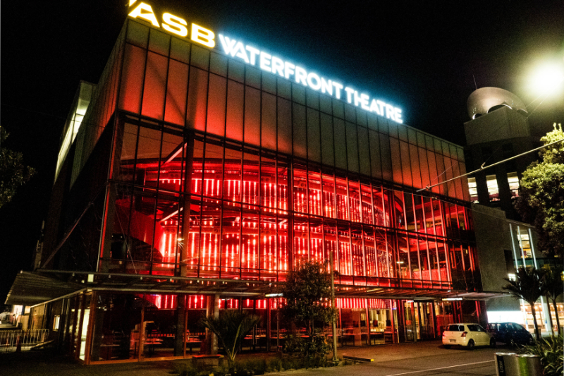 A night photo showing the ASB Waterfront Theatre illuminated by the artwork 